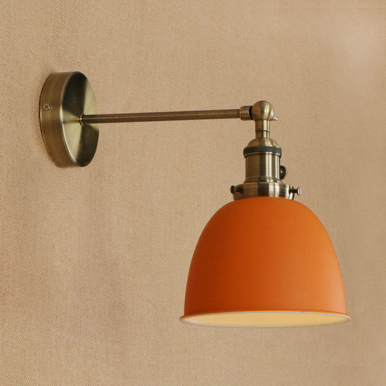 Orange dome-shaped bedroom wall sconce with brushed nickel finish and adjustable arm for versatile lighting