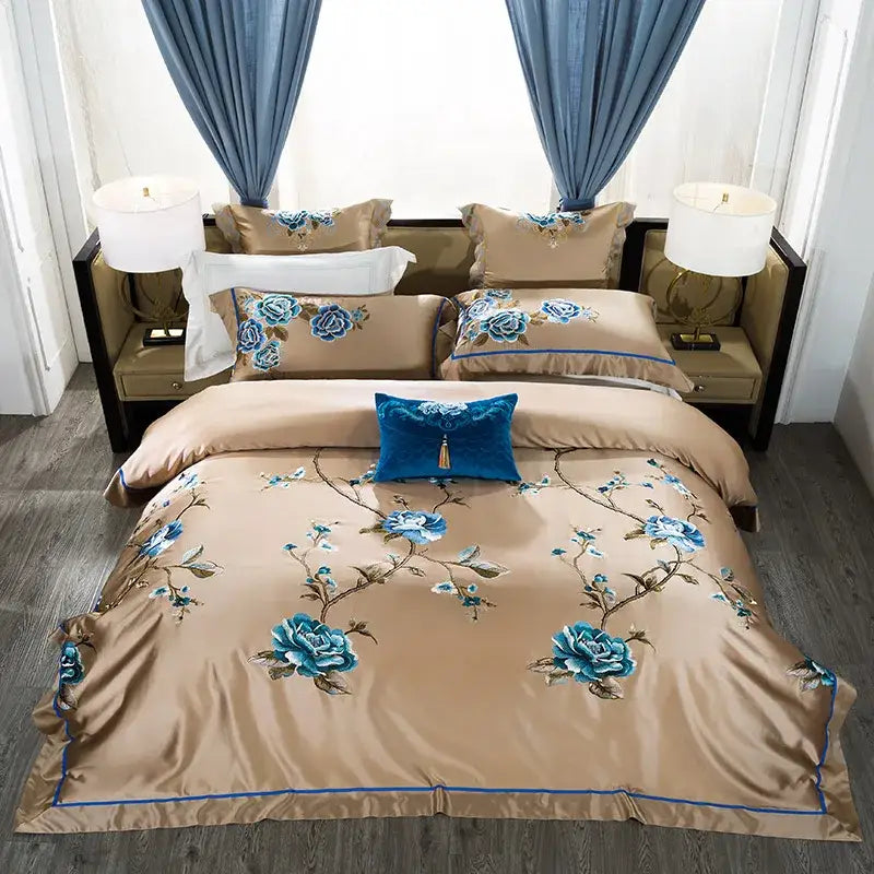 Beige satin bedding set with intricate blue floral embroidery and royal blue velvet pillow accents egyptian cotton bedding