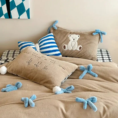 Beige and blue embroidered velvet duvet bedding set with tan plush bed set featuring teddy bear pillow and blue bow accents