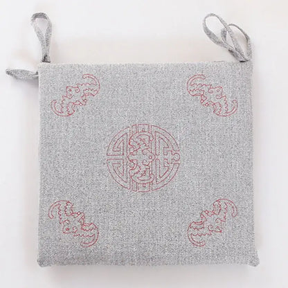 Gray woven linen seat cushion with red embroidered dragon motifs and fabric loops for hanging by decorbites