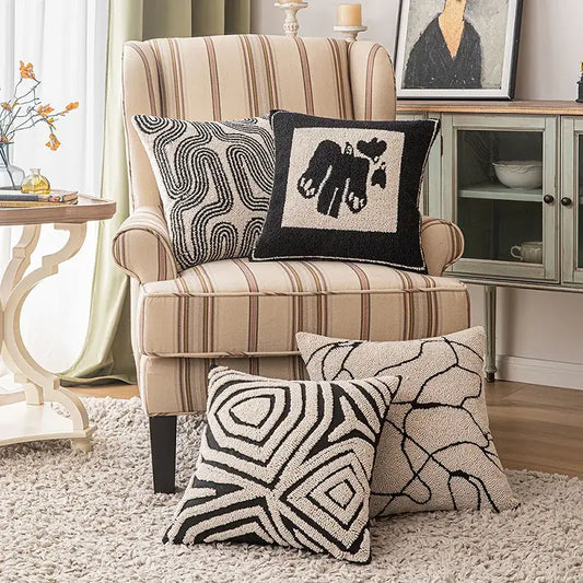 Beige and brown striped wingback armchair with black and beige decorbites geometric line art cushion cover pillows