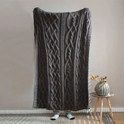 A thick dark gray knitted throw blanket with a prominent cable knit pattern for decorbites beige chunky knit tassel decor