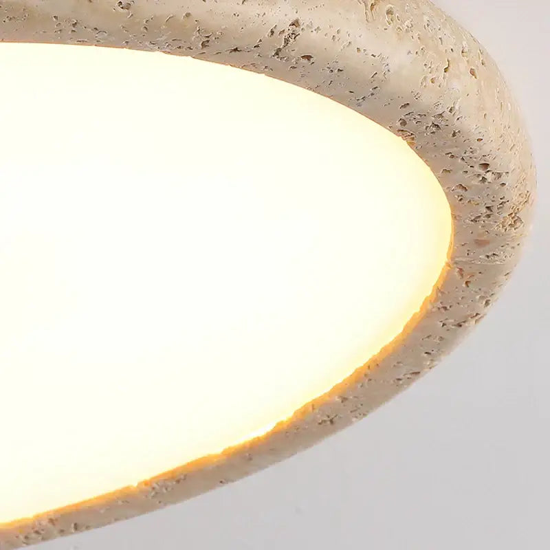 Beige textured stone pendant light with warm diffused glow in a brass led flush mount ceiling lamp for living room