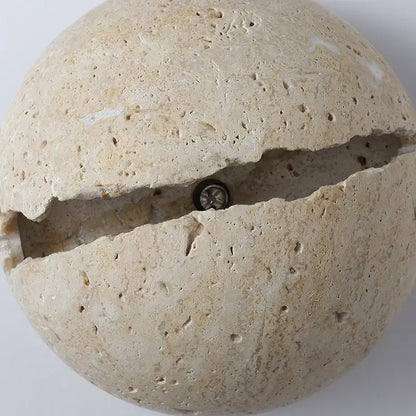 Beige dino egg stone wall lamp with gold accent featuring a split design revealing an embedded bulb by decorbites