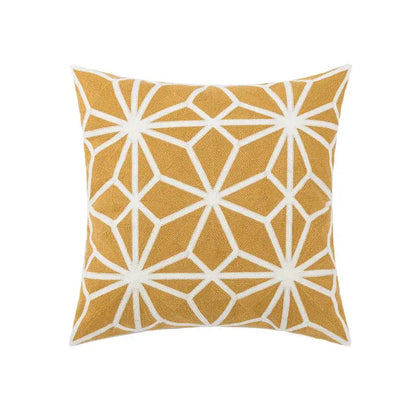 A square pillow cover with mustard yellow base and white embroidered daisy floral starburst patterns for bedroom decor