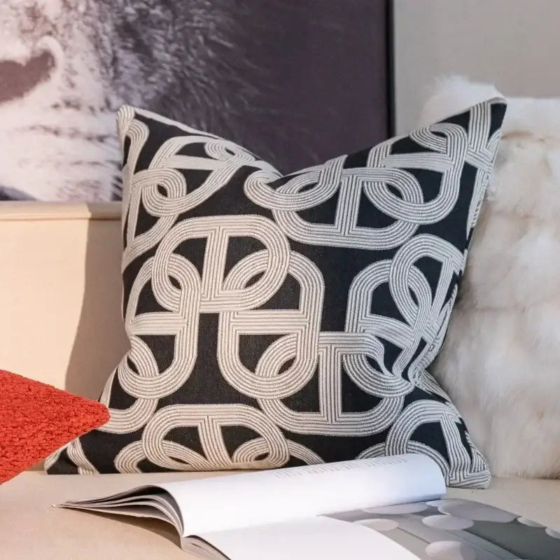 Black throw pillow with intricate white geometric embroidery complementing decorbites geometric jacquard cushion cover