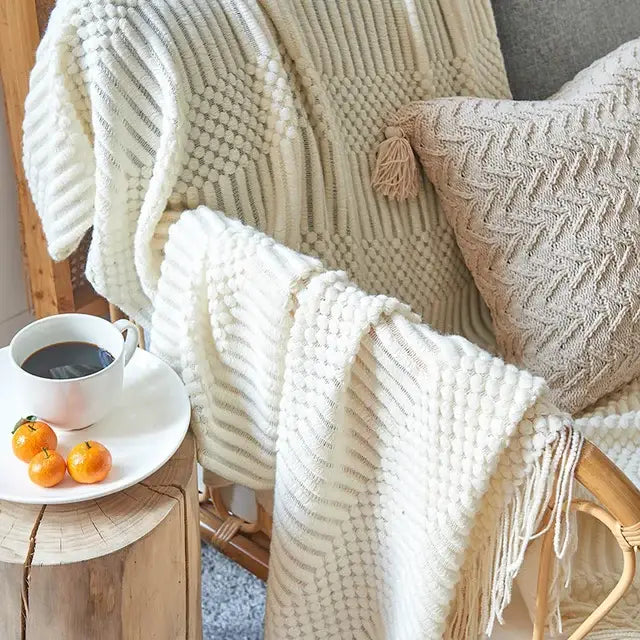 Beige decorbites 3d knitted tassel blanket with textured ribbed pattern and cream-colored knitted tassel fringe decor throw