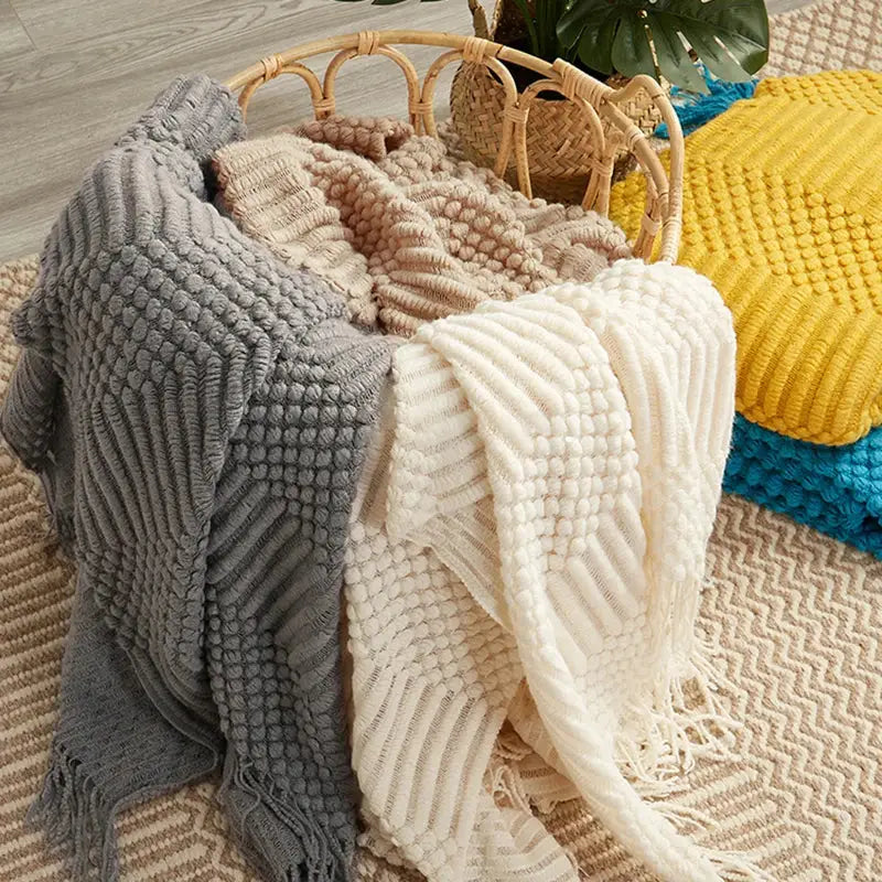 A cozy soft gray decorbites 3d knitted tassel blanket with ribbed pom-pom pattern perfect for bedroom throw decor