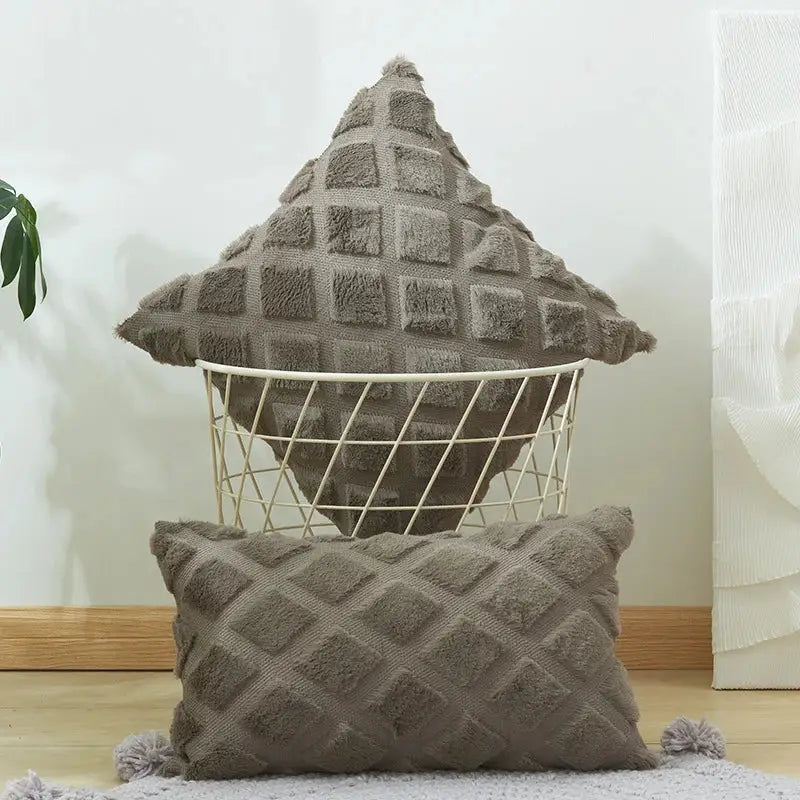 A cozy gray cushion cover with a geometric diamond pattern and fluffy pom-poms for living room decor
