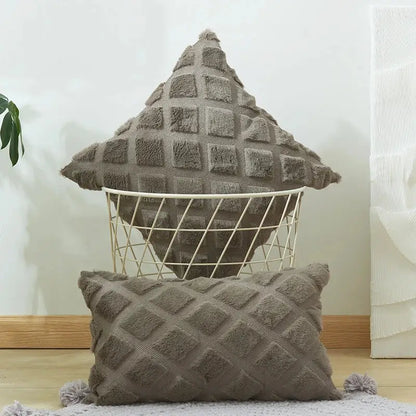 A cozy gray cushion cover with a geometric diamond pattern and fluffy pom-poms for living room decor
