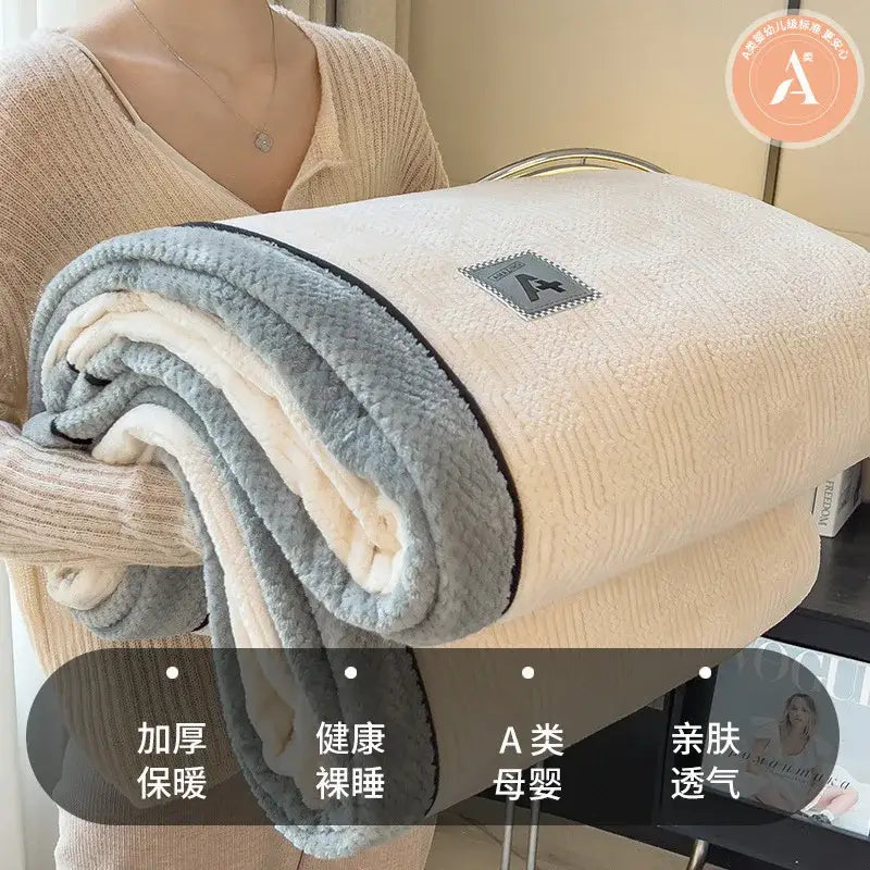 A beige and gray luxury velvet plush cotton throw blanket with soft textured fleece surface and black trim