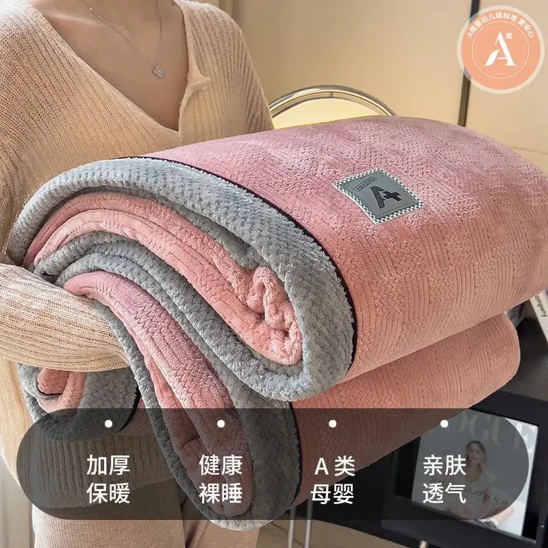 A plush pink and gray fleece blanket with a soft textured surface and luxury velvet plush cotton material throw
