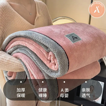 A plush pink and gray fleece blanket with a soft textured surface and luxury velvet plush cotton material throw