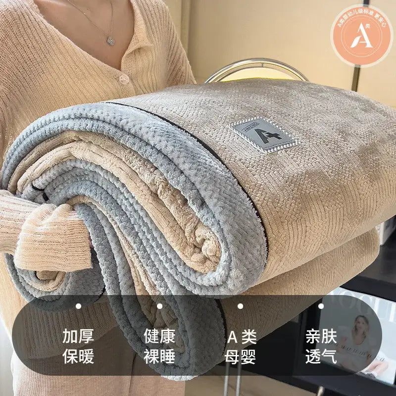 Beige and gray luxury velvet plush cotton blanket rolled up with soft textured surface and branded patch for bedroom use