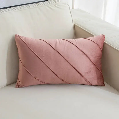 A soft pink velvet rectangular pillow with diagonal hand pleat embroidered stitching for living room use