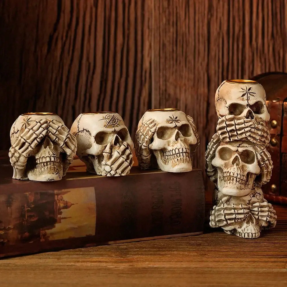 Set of three beige resin bone skeleton candlestick holders featuring hand covering one eye and star tattoos for decorbites bone skeleton decor