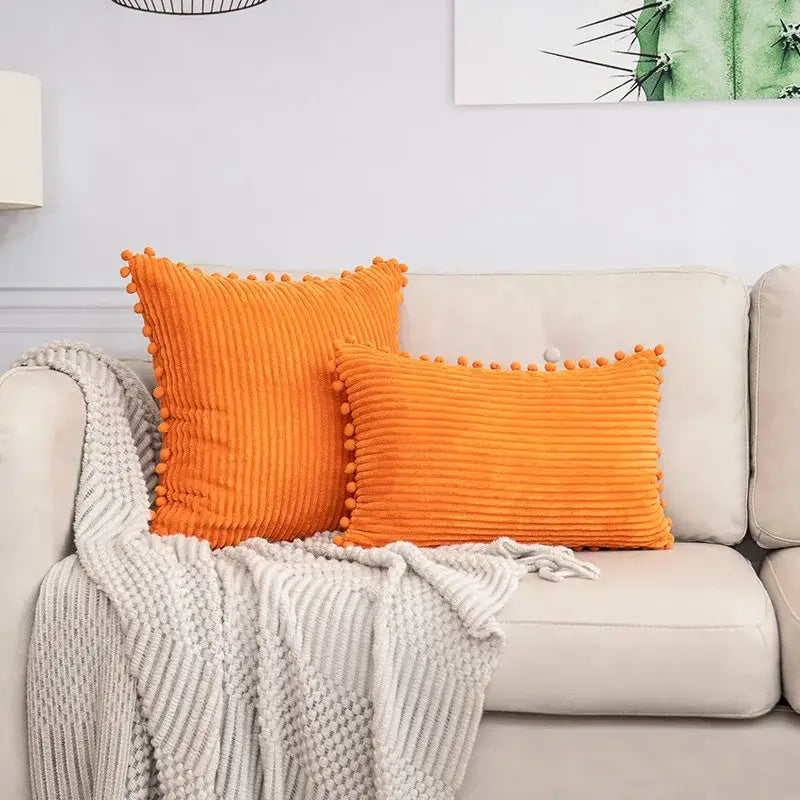 Vibrant orange corduroy throw pillows with pom pom trim complement decorbites beige striped cushion cover