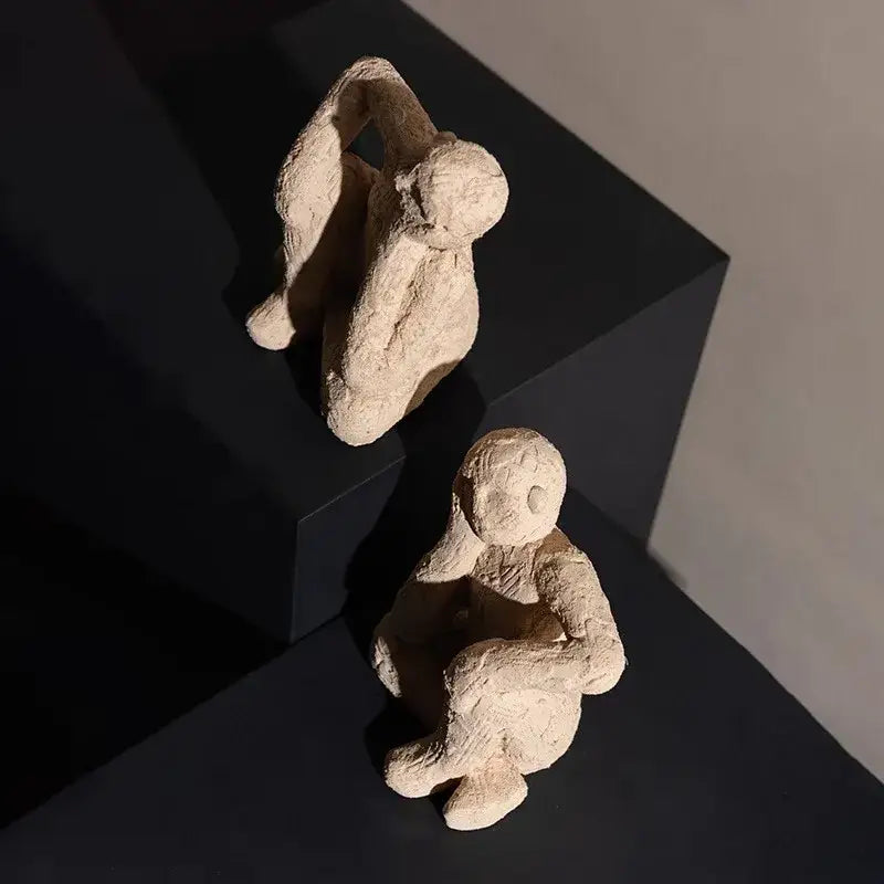 Two beige textured clay abstract resin figurine sculptures in seated poses for living room decorbites abstract resin decor