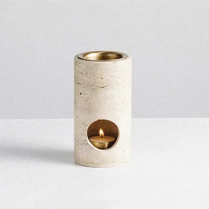 Beige travertine stone essential oil burner with cream-colored stone diffuser and brass interior housing lit tea light candle