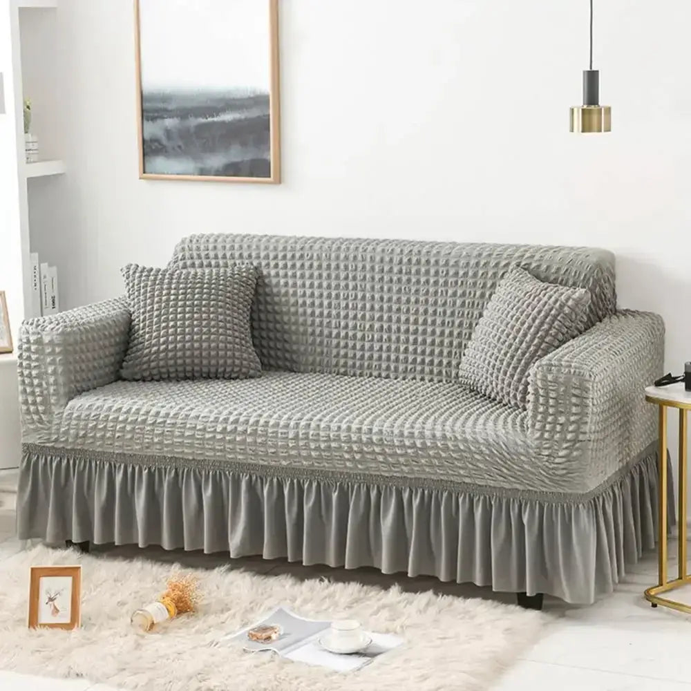 Gray waffle-textured cozy sofa cover with stretch fabric and ruffled hem for living room slipcover use