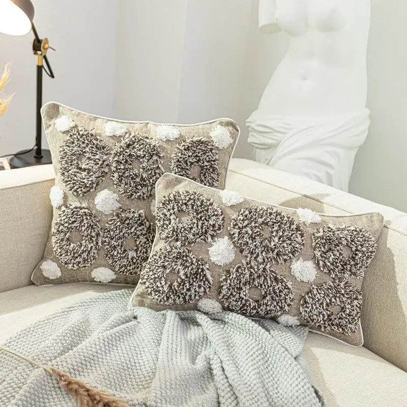 Beige and white diamond tufted zigzag cushion cover with textured fluffy circular patterns and white pom-poms for living room decor
