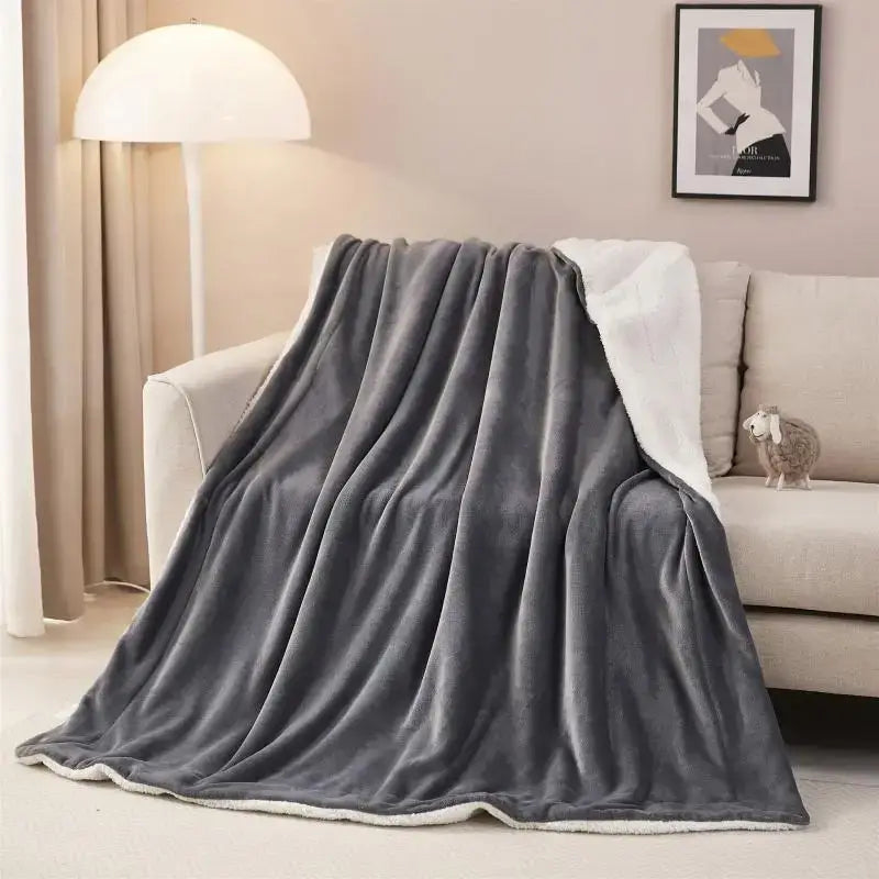 A plush gray and white cozy sherpa twin blanket draped over a sofa for decorbites cozy sherpa bedroom use