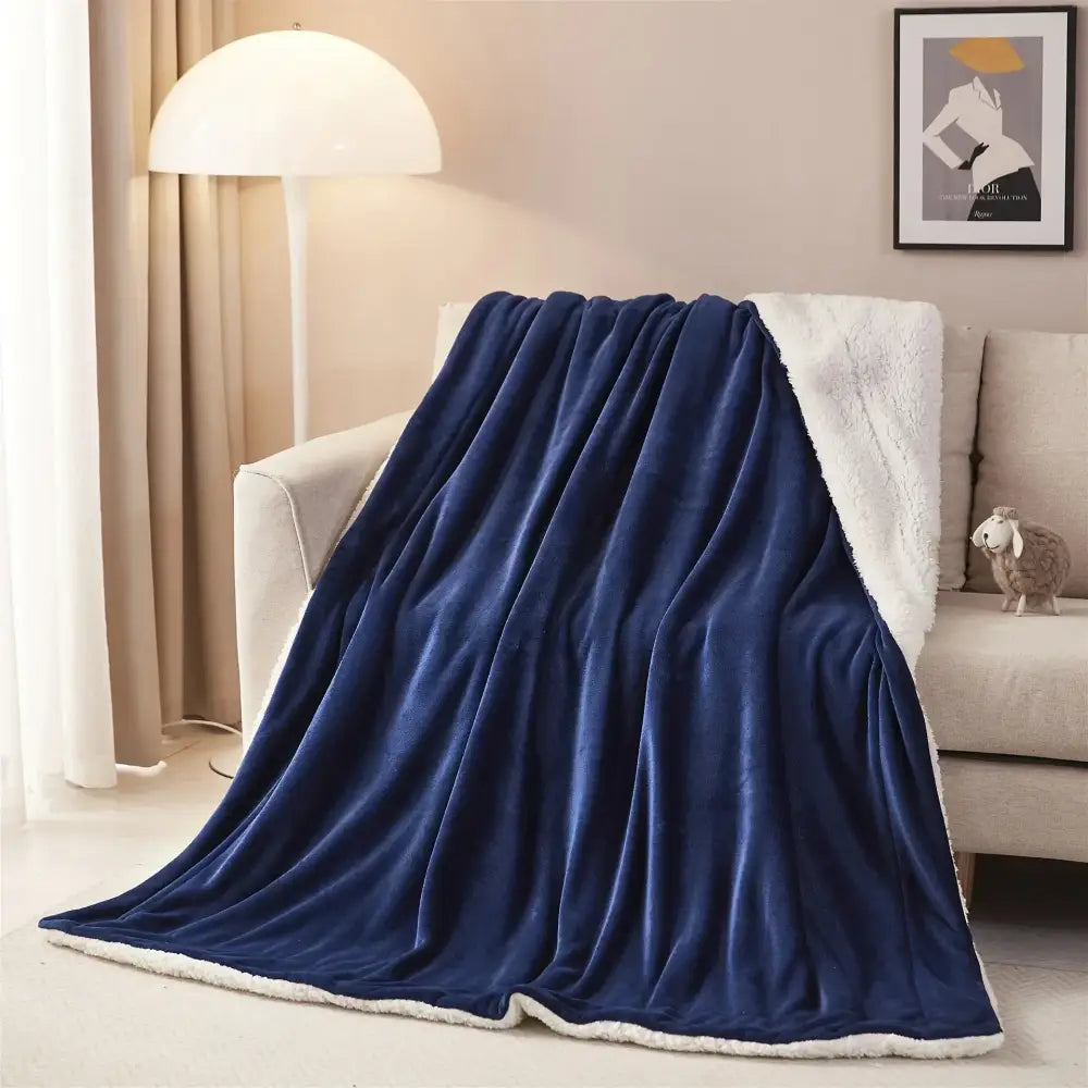 A plush navy blue and white sherpa twin blanket draped over a sofa showcasing decorbites cozy sherpa style