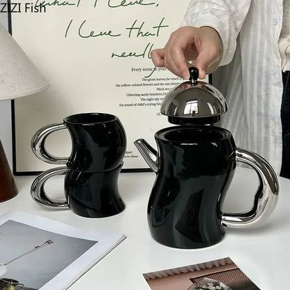 Black ceramic teapot with shiny silver lid and handle featuring abstract sculptural design for decorbites bending design ceramic set