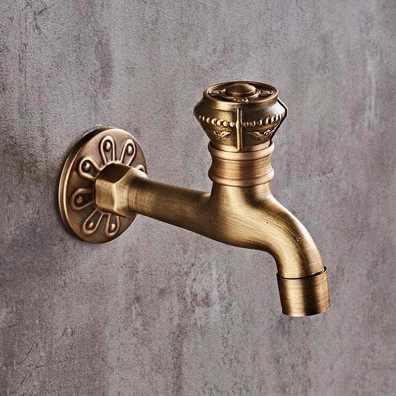 Antique brass wall mounted bibcock faucet with ornate floral base plate for garden outdoor and bathroom use