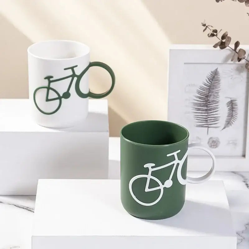 White and dark green ceramic toothbrush holder cup featuring bicycle designs and contrasting handles for bathroom use