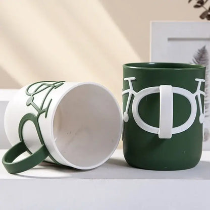 Green ceramic toothbrush holder cup with white bicycle design and handle for bathroom use