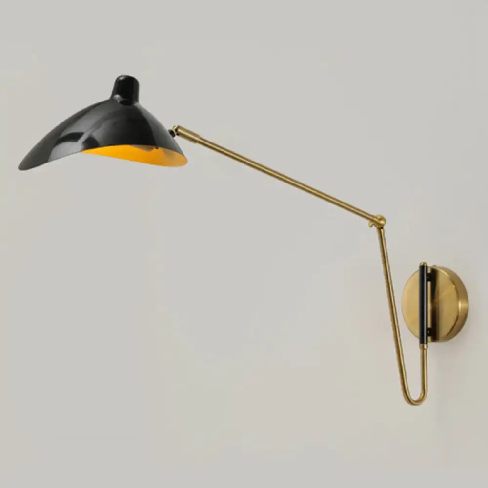 Black and brass wall lamp with adjustable joint and sleek curved arm featuring a reflective duckbill reading light interior