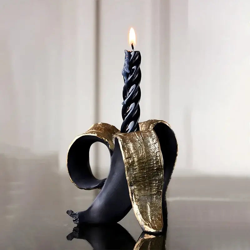 Black twisted candle in a black and gold decorbites golden banana candlestick holder for dining room decor