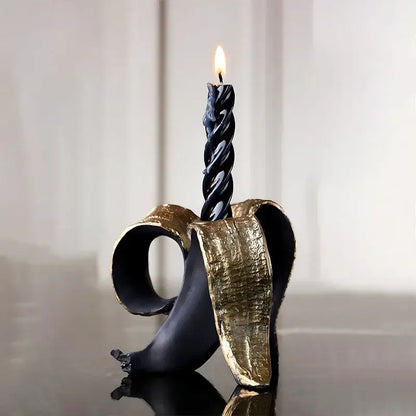 Black twisted candle in a black and gold decorbites golden banana candlestick holder for dining room decor