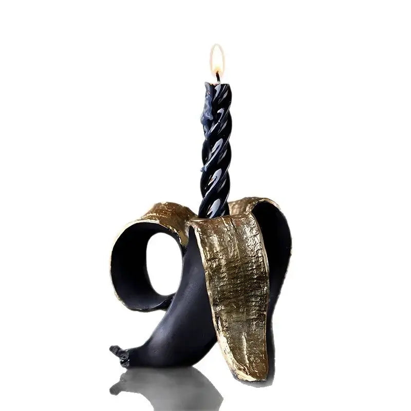 Black twisted candle in black and gold banana candlestick holder with gold foil detailing for dining room decorbites