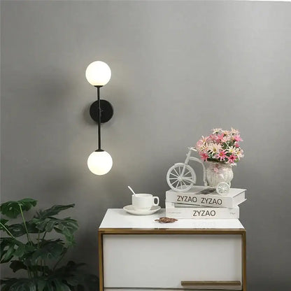 Modern black wall lamp with dual white glass globes featuring decorbites golden glass led design for bedroom decor
