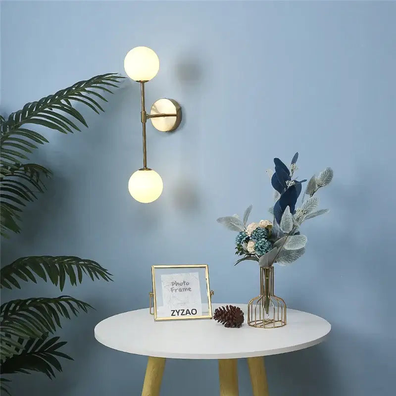 Gold-toned double globe wall lamp with frosted glass shades black and gold glass wall decorbites golden glass led