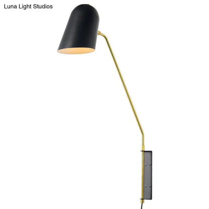 Black and gold reading light with a black metal shade mounted on a gold articulated arm for led incandescent use