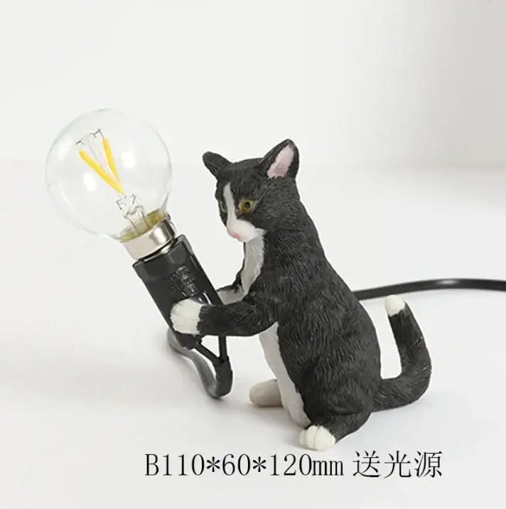 Black and white cat resin table lamp holding a clear glass bulb with yellow filaments for bedroom decorbites cat resin decor