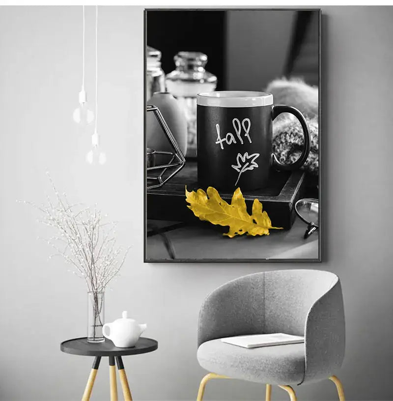 Black ceramic mug with white fall text and leaf design beside yellow autumn leaf in DecorBites white nordic landscape canvas set