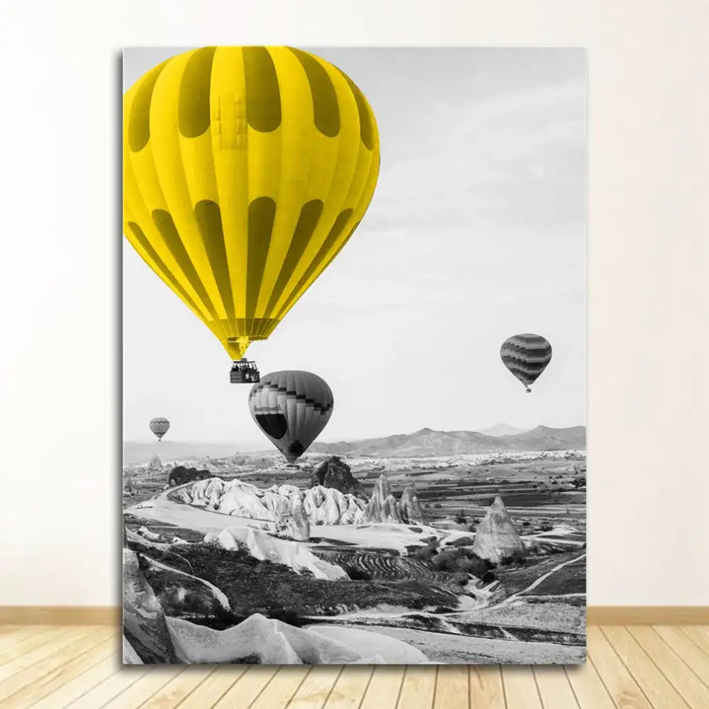 Vibrant yellow hot air balloon contrasts with a black and white nordic landscape canvas in decorbites™ landscape canvas set