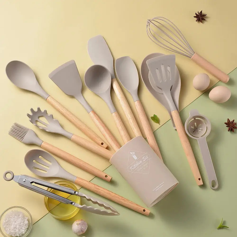 Set of gray silicone kitchen utensils with wooden handles neatly arranged in a black kitchen utensil set storage box