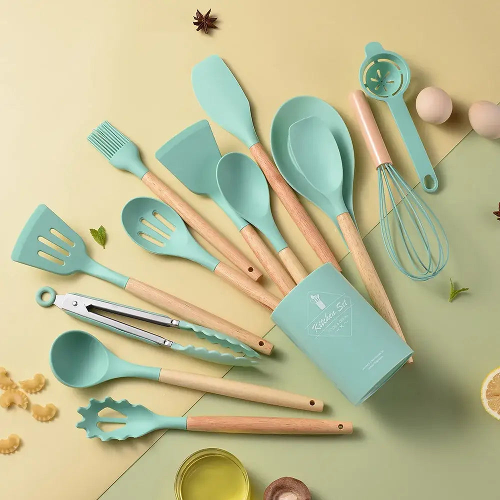 Teal silicone kitchen utensil set with wooden handles neatly arranged around a matching black and wood storage box