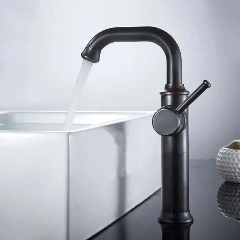Black antique brass basin faucet in matte black with curved spout and single lever handle over white sink by decorbites