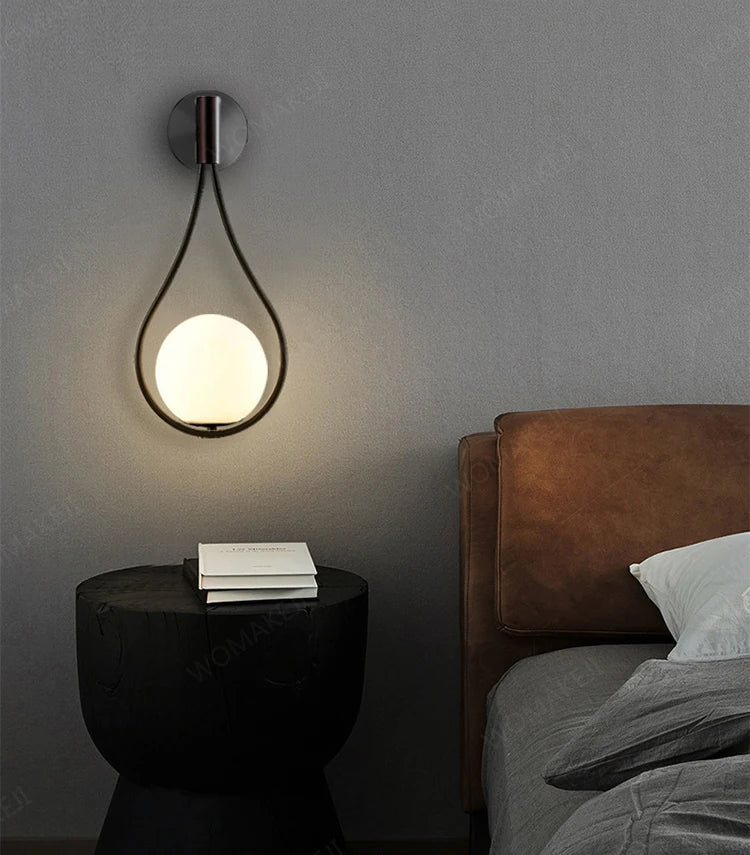 Teardrop-shaped wall lamp with illuminated globe.