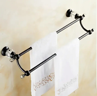 Black brass bathroom accessories set featuring a black metal towel rack with crystal accents holding white towels
