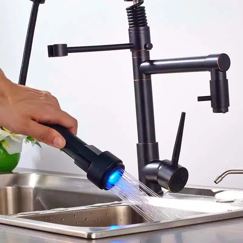 Black bronze dual spout kitchen faucet with a black matte finish and led sprayer emitting blue light by decorbites