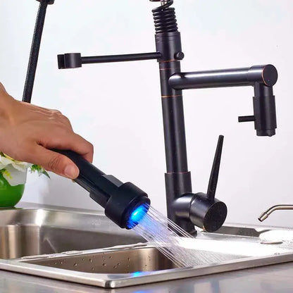 Black bronze dual spout kitchen faucet with a black matte finish and led sprayer emitting blue light by decorbites