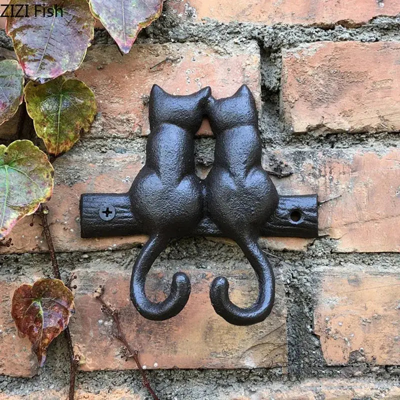 Black cast iron cat hook shaped like two cats sitting back-to-back with curved tails for hanging shelf decorbites cat hook