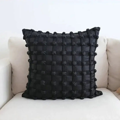 Black dot bubble quilted cushion cover with textured grid pattern and pom pom accents for stylish home decor